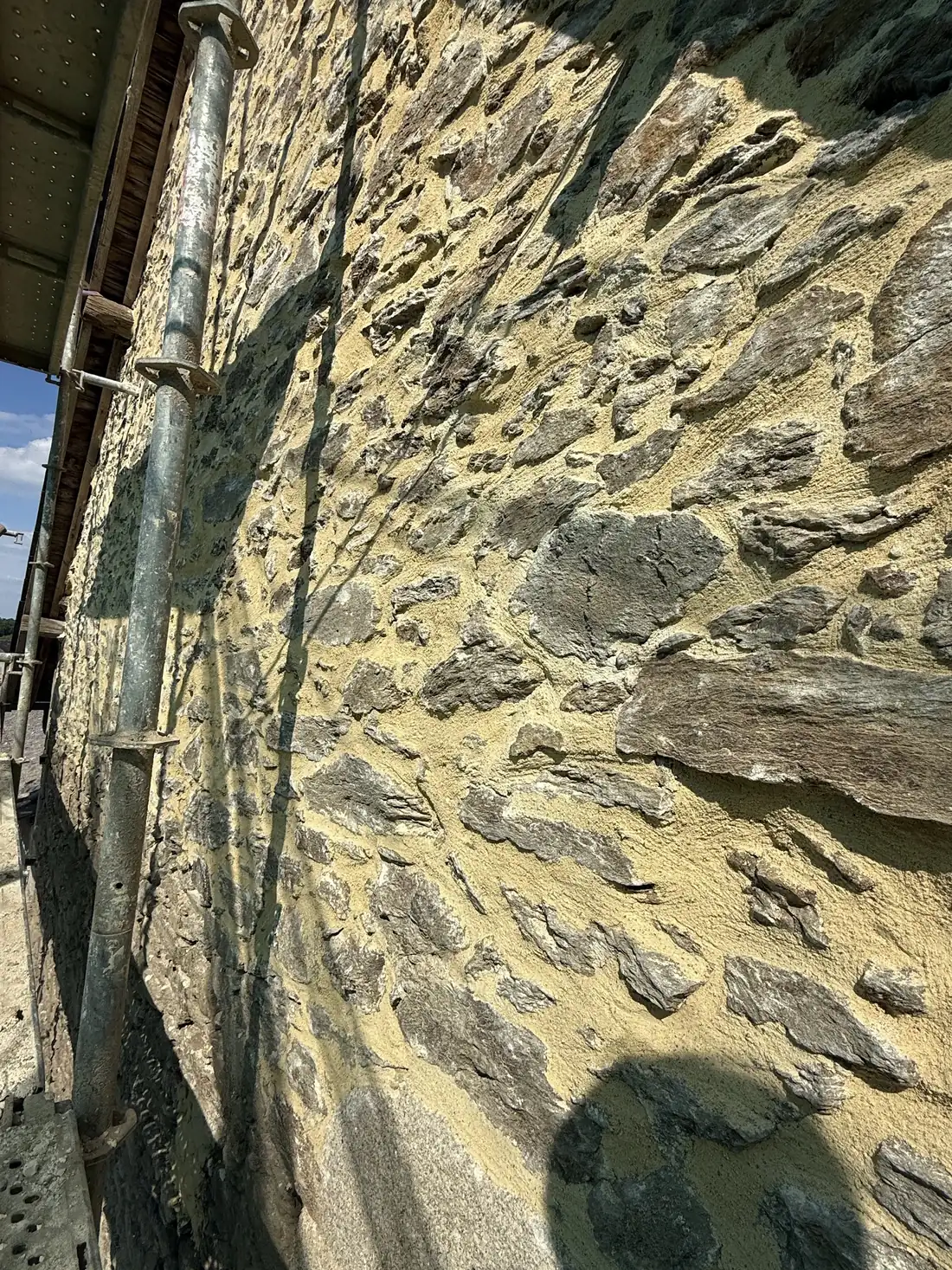 Mur en pierre aux joints refaits, gouttière en zinc